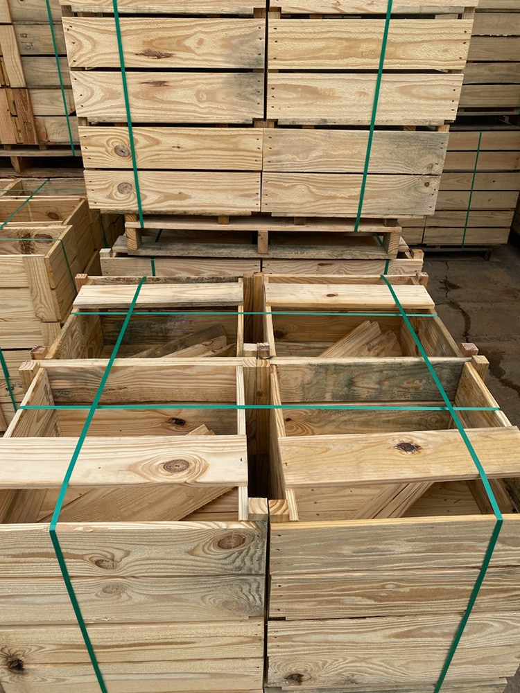 Wooden crates, customized by Valley Pallet and Crating, are used for warehouse storage solutions to save space.