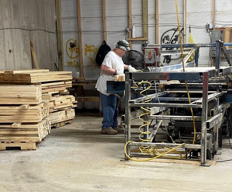 Valley Pallet and Crating employee cutting wood pieces to begin assembling custom sized wooden skids.