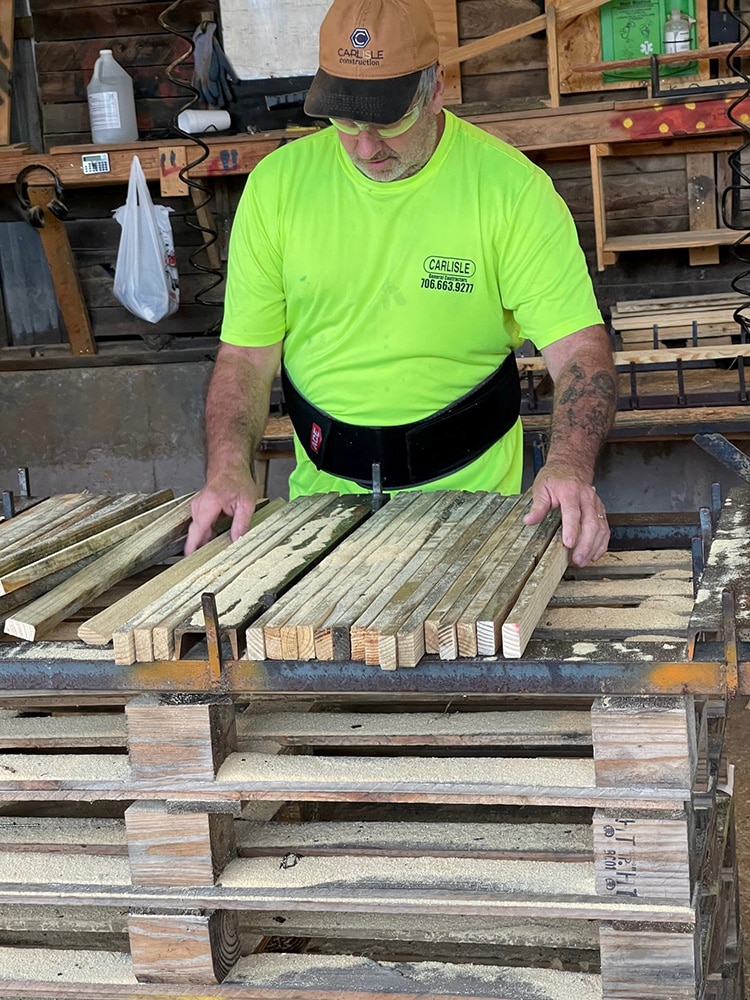 Man lining up custom cut lumber pieces in the Valley Pallet and Crating manufacturing facility in Pine Mountain, GA.