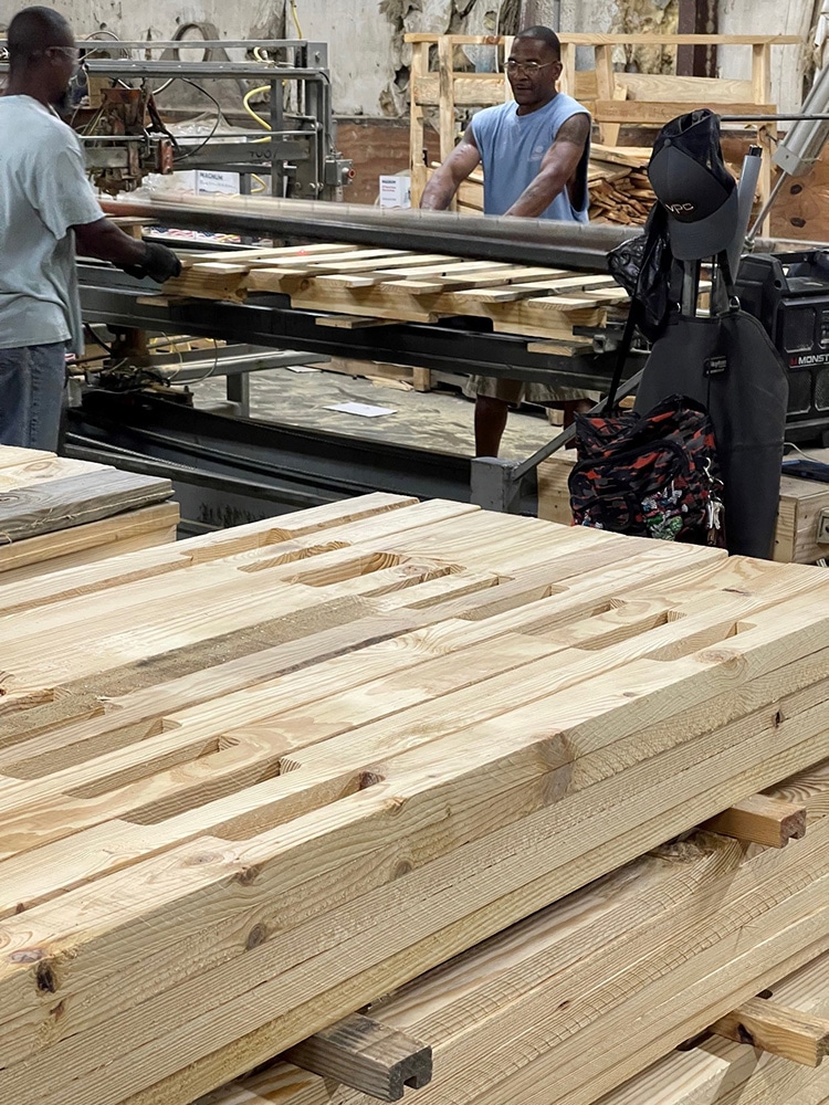 Two men in Valley Pallet and Crating manufacturing working with wood that will be used to make skids, pallets, and crates.